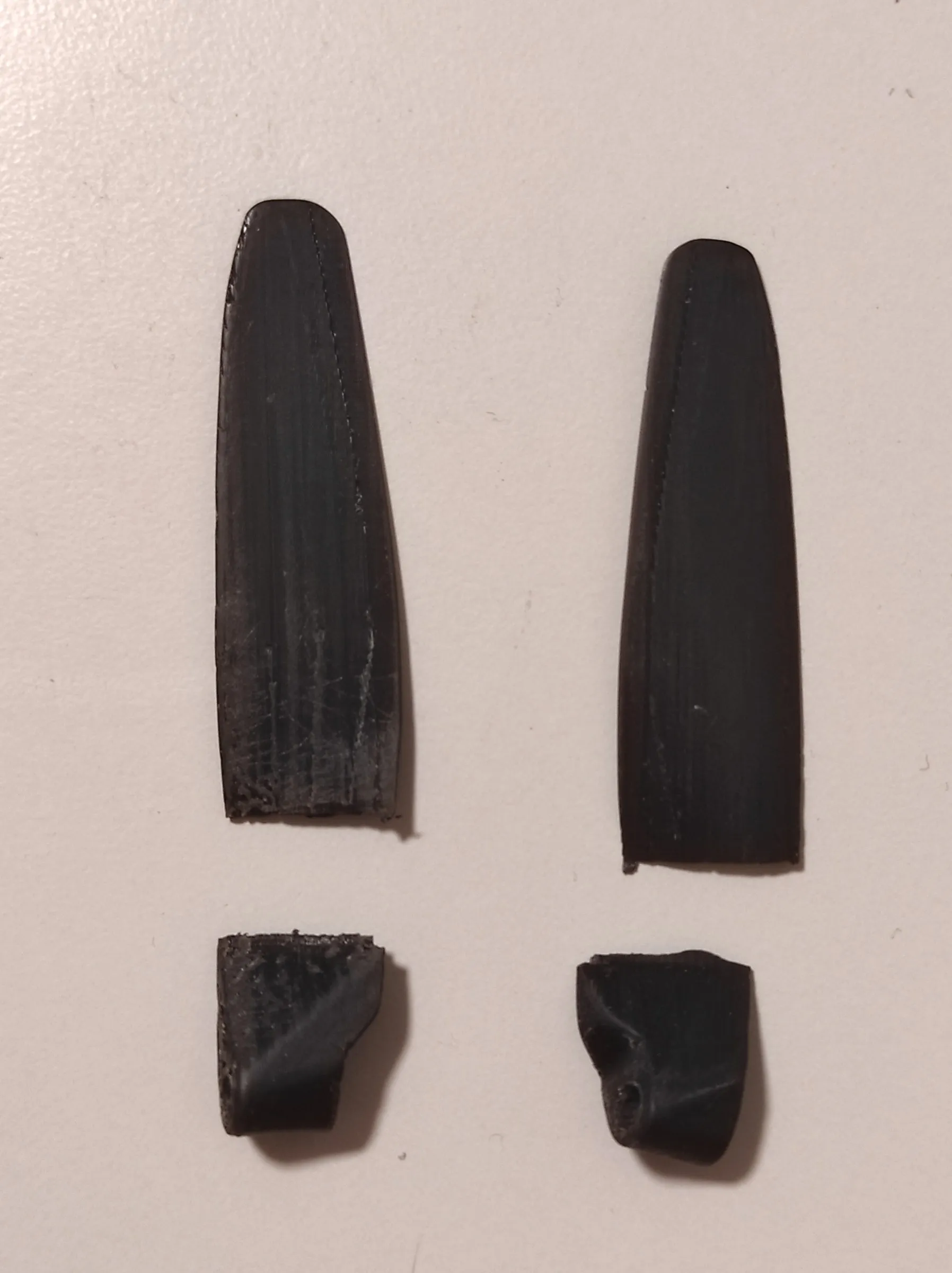 two black printed propeller blades, each snapped off just above its root
