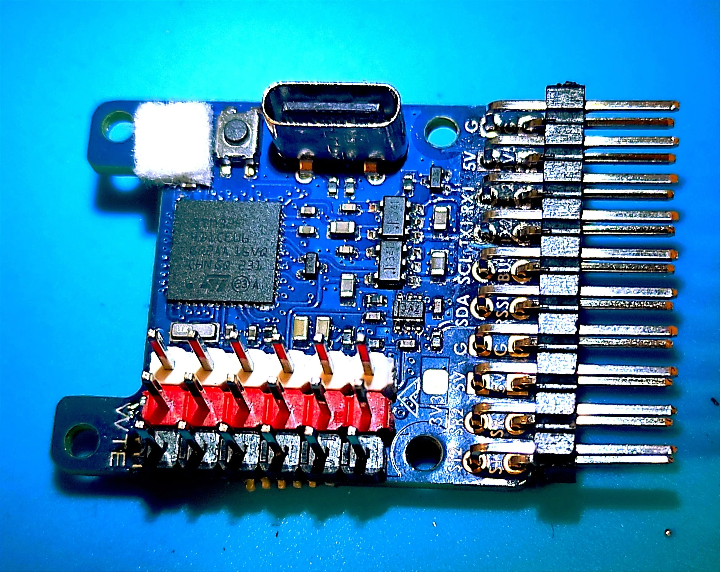 the same flight controller with straight and angled pin headers soldered along two edges